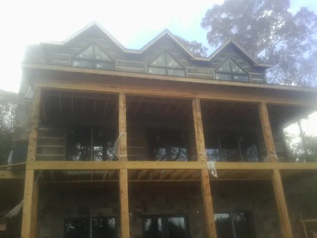 Dormers and porch framing on a large log home under construction — Roof Coating work by our crew in San Ramon