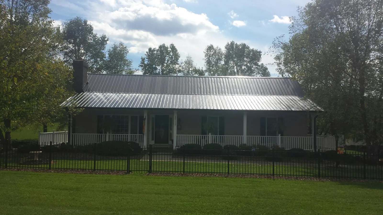 Gray metal roof on a brick ranch with a full width front porch — Gutter Guard Installation work by our crew in San Ramon